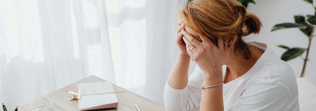 Reviewing finances with a calculator and budget planner to stretch pay cheque and find budgeting hacks.