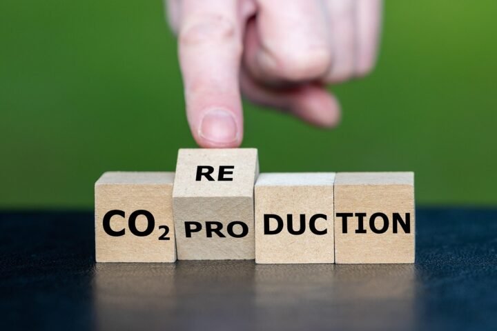 3D cubes spelling CO₂ with a green arrow pointing down, metaphor for reduction and cutting high-interest debt fast