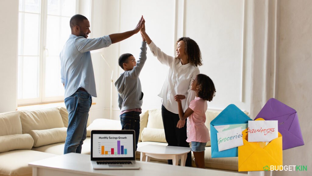 4 Powerful Family Budgeting Secrets 2 Happy family celebrating savings progress while reviewing household budget on laptop in bright living room.