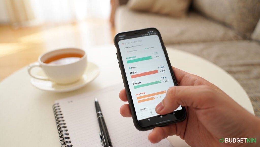 4 Powerful Family Budgeting Secrets 4 Smartphone displaying a budgeting app with spending categories and savings goals in teal and coral tones.